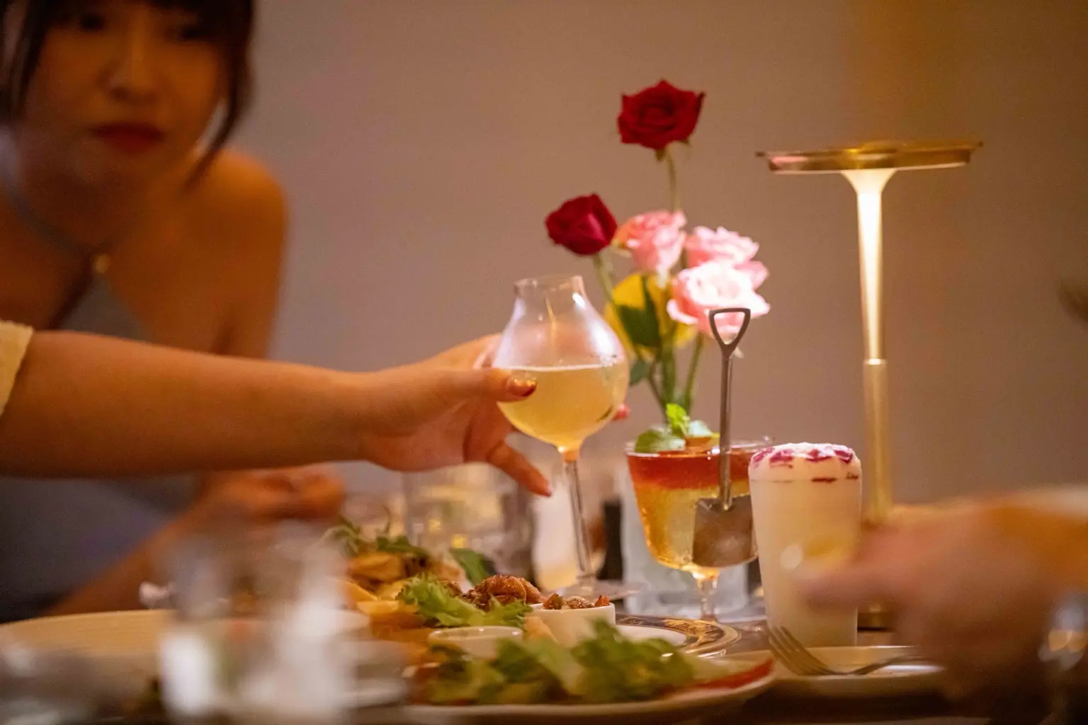 客人在美月餐桌前舉杯,桌上擺著料理與調酒